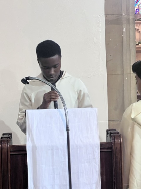 Altar servers standing in white albs during Mass