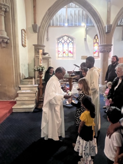 Parishioners receiving Communion beside the sanctuary steps